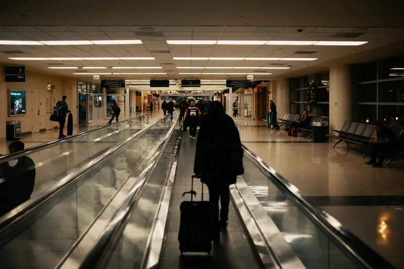 pasajeros caminando por la cinta hacia la salida del aeropuerto
