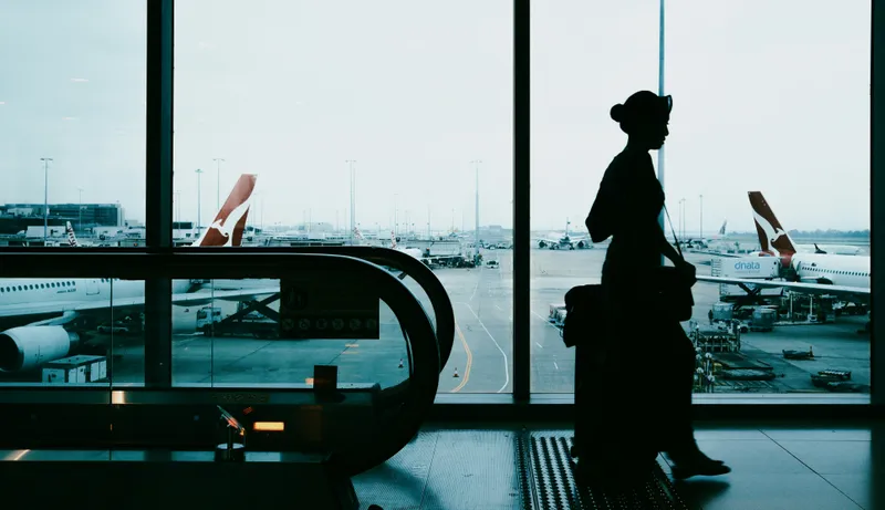 mujer con maleta saliendo del avión hacia la terminal